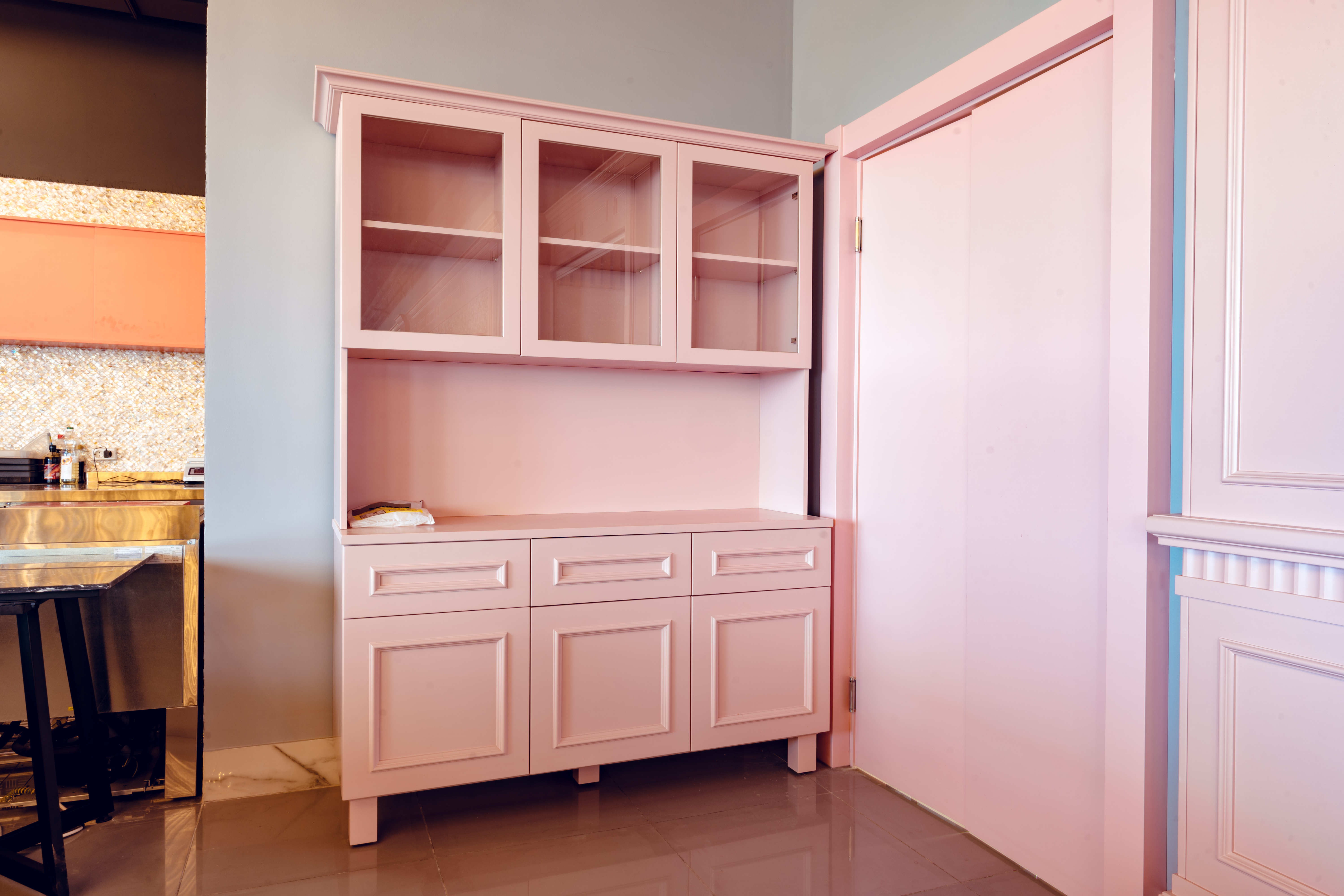 Empty pink wooden cupboard for dishware in cafe interior