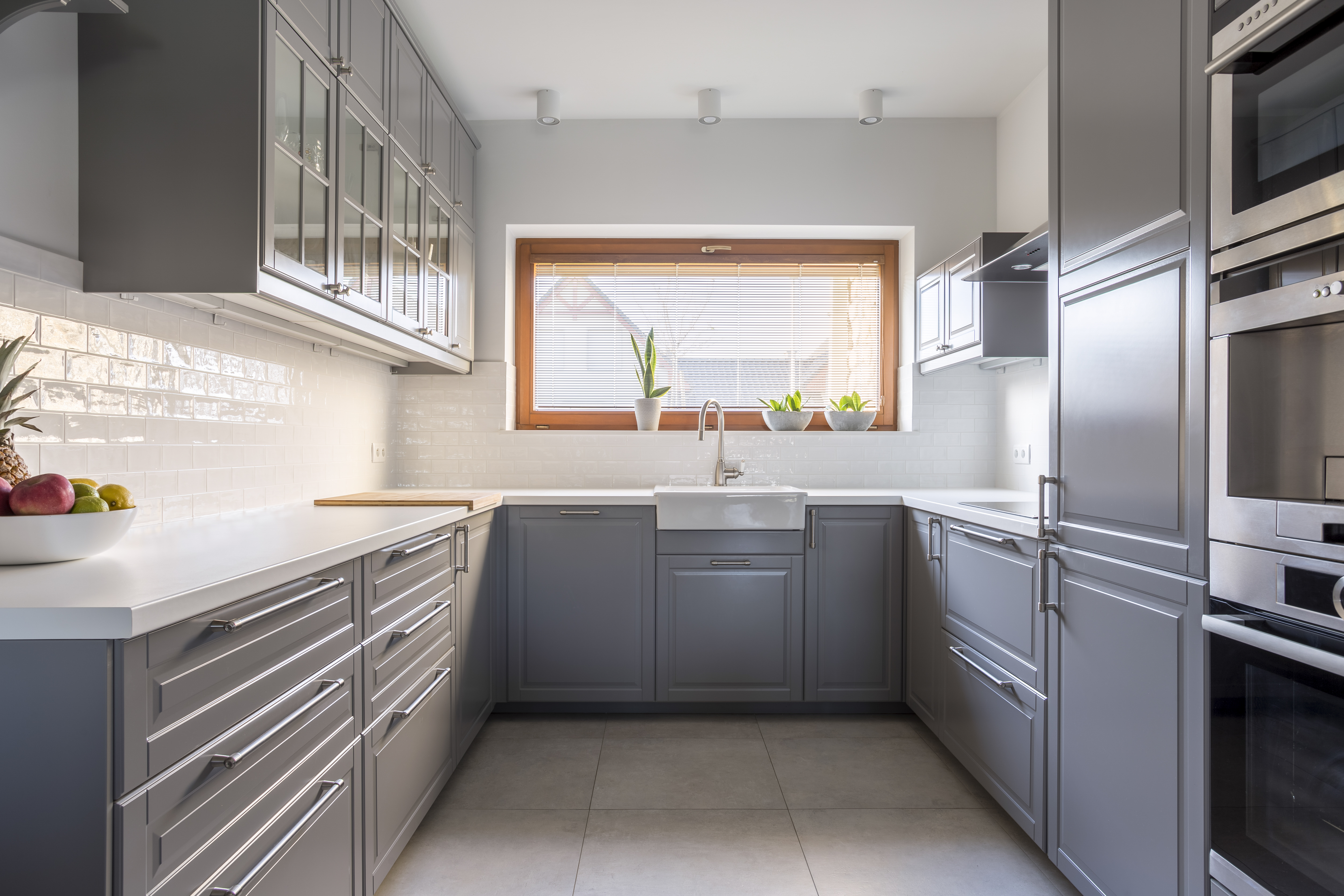 Light, spacious kitchen with window and white brick tiles
